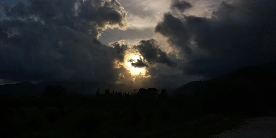 there are clouds in the sky and sunlight coming through them