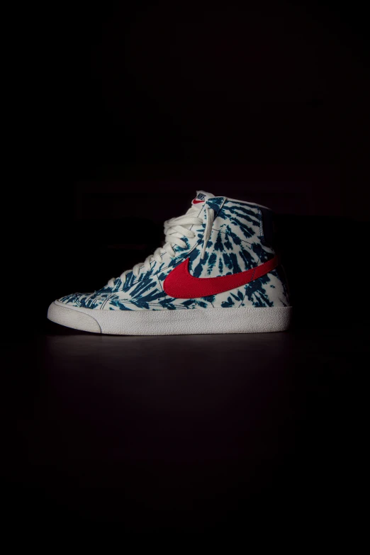 a pair of blue sneakers with a red and white pattern on it