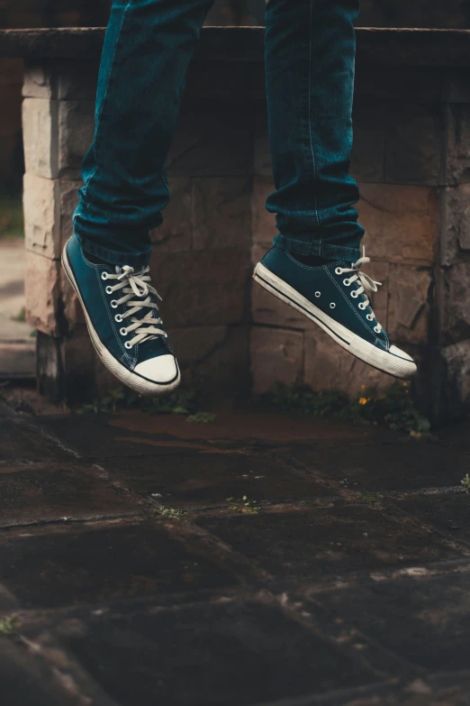 the legs and foot of an person standing on a cement ledge