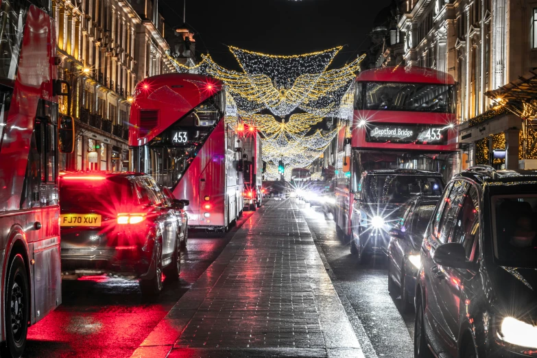 traffic is driving along the sidewalk at night in this town