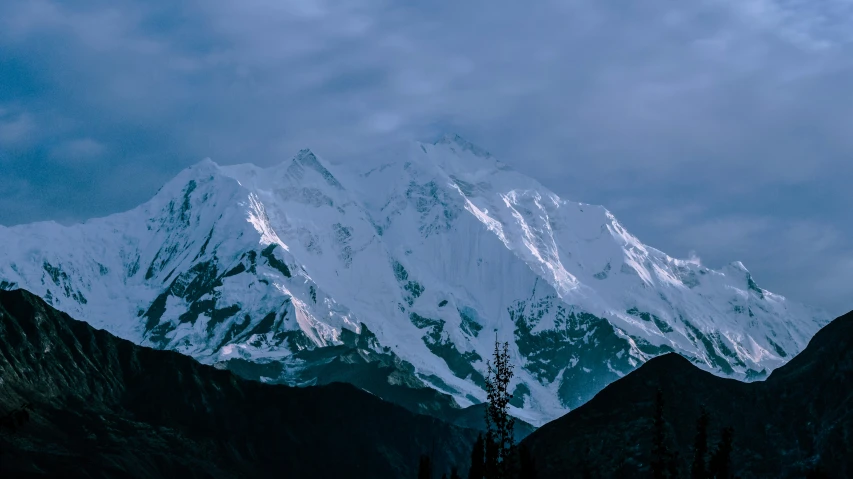 a large snowy mountain on a cloudy day