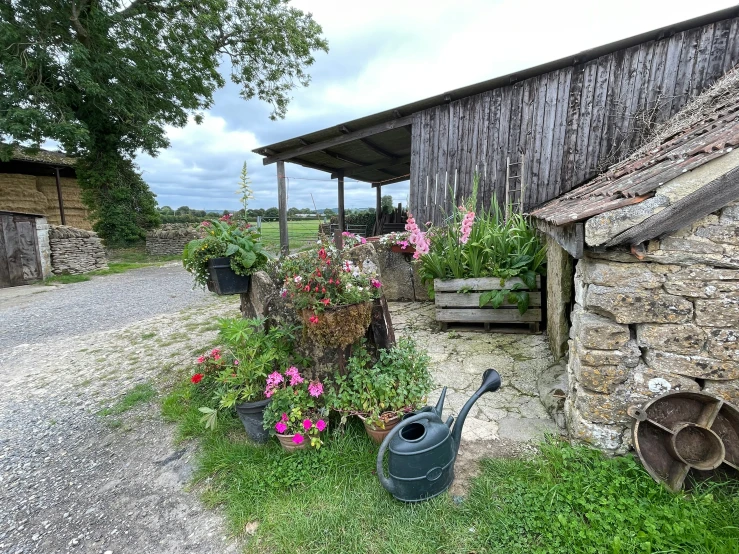 an old fashioned barn next to a garden