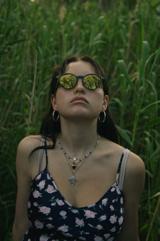 a woman is wearing sunglasses and is posing