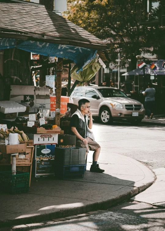 there is a man sitting at the corner on the cell phone