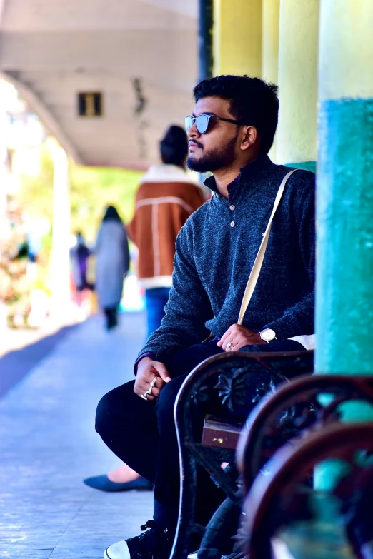 a man in sunglasses sitting on a bench