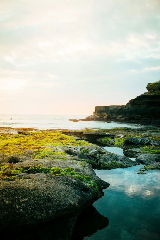 there is a man fishing from the rocks in the water