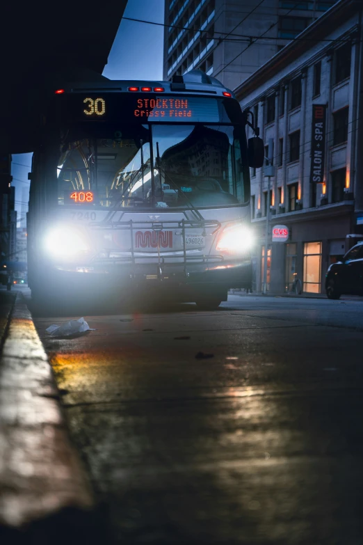 a city bus turning a corner in the dark