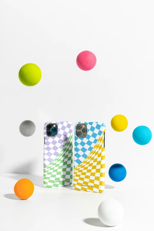 two cell phones, one has its case made out of colored balls and the other is being used for pography