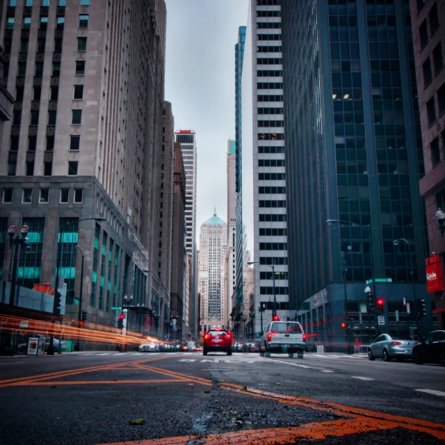 a street with lots of cars on it and tall buildings