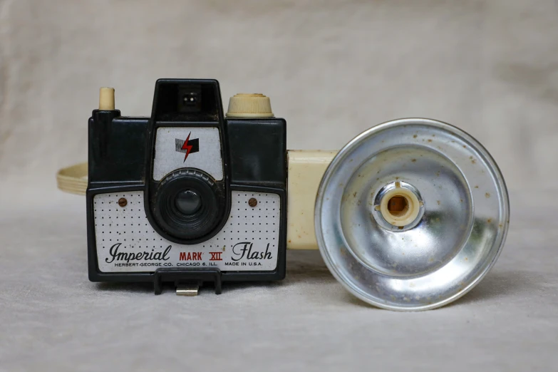 an old style camera with a bell attached to it