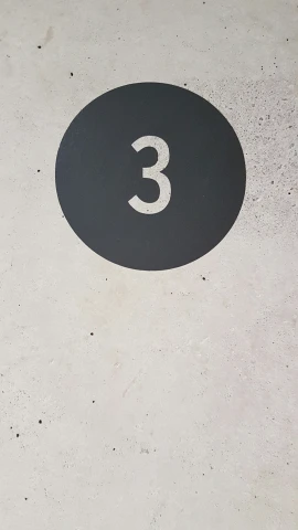 the number 3 sits on the concrete wall