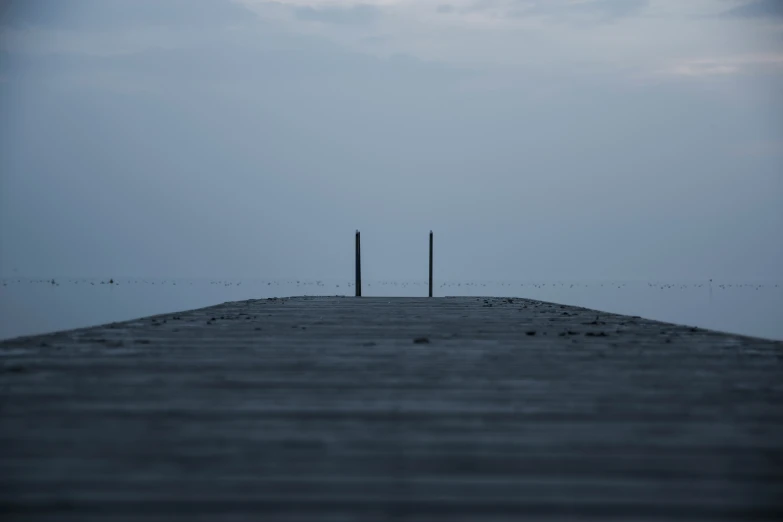 two poles are at the end of a long pier