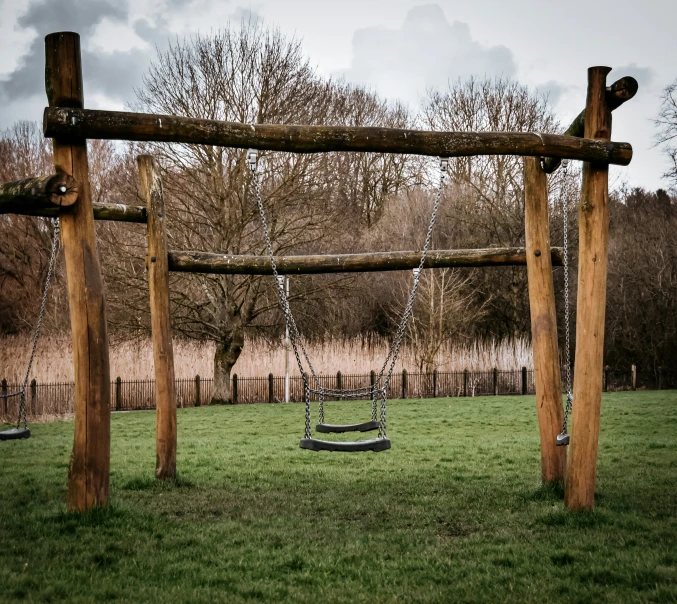 an empty swing set in the grass