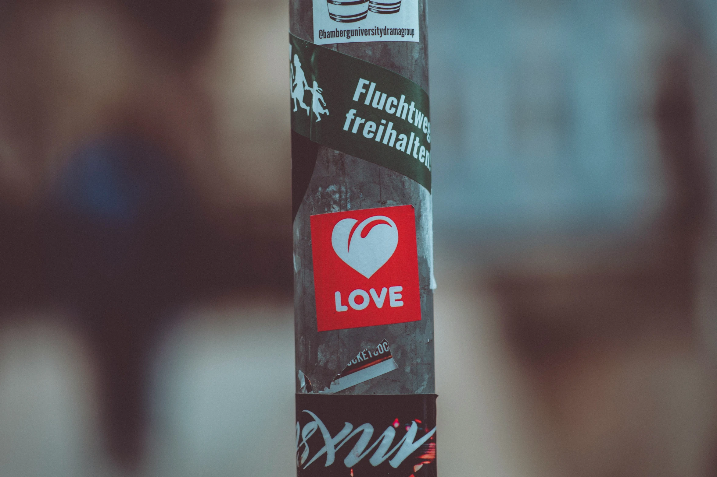 an old wooden pole covered in various stickers