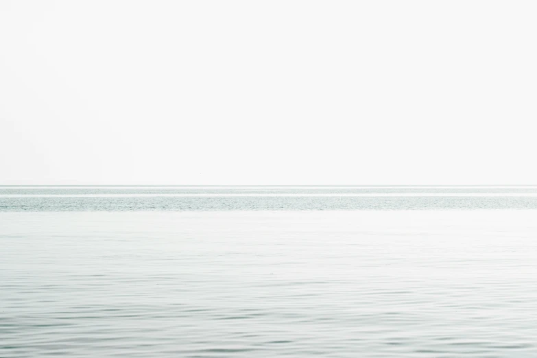 the person stands on a surfboard in shallow water