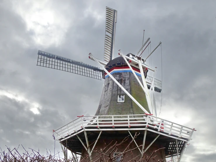 a old windmill has been painted with colorful stripes