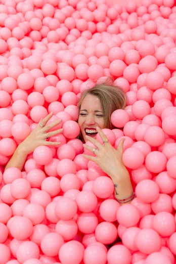 woman in pink balls pool with eyes closed