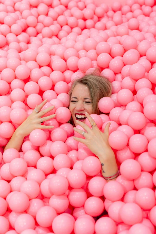 woman in pink balls pool with eyes closed