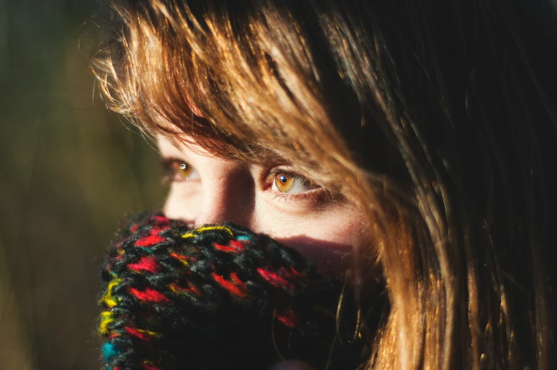 a woman with a colorful mitt covering her mouth