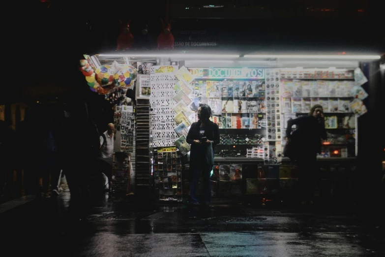 several people standing outside a store on a dark street