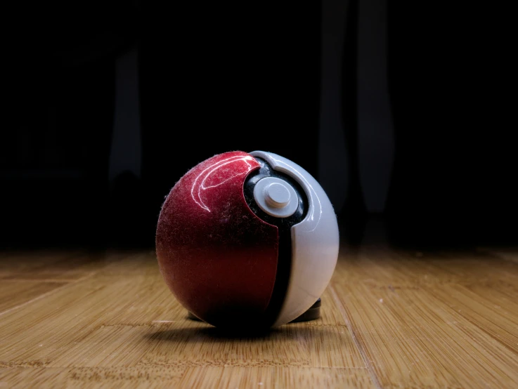 there is a red and white ball sitting on the ground