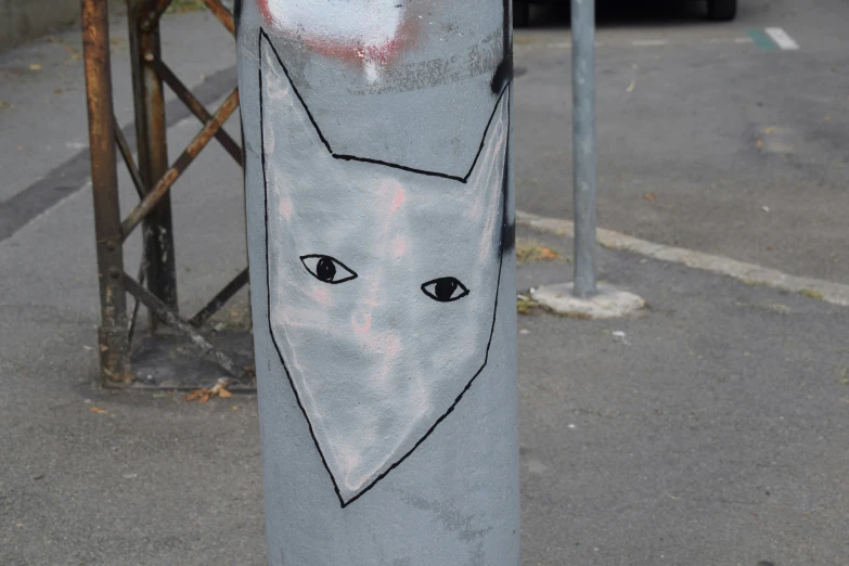 an interesting art piece with cats painted on a pillar