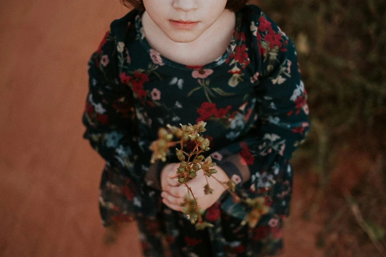 a young child is holding flowers in his hands