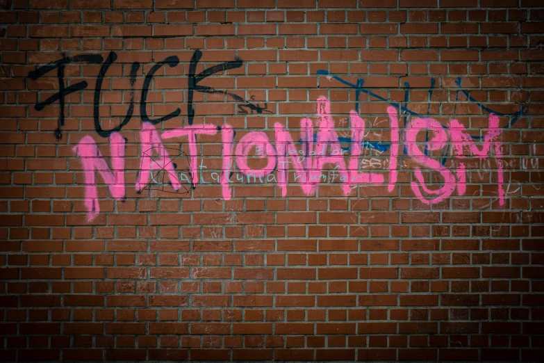 graffiti written on a wall that has pink and blue spray paint