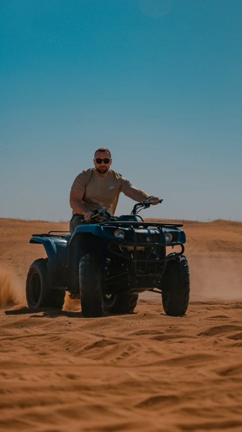 a man riding on the back of an atv through the desert
