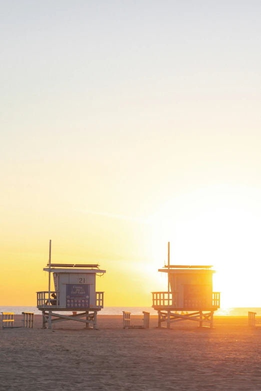 a beach scene with two lifeguard towers next to each other