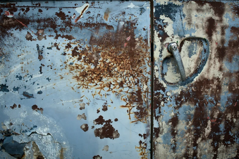 the side of a rusty door is peeling paint