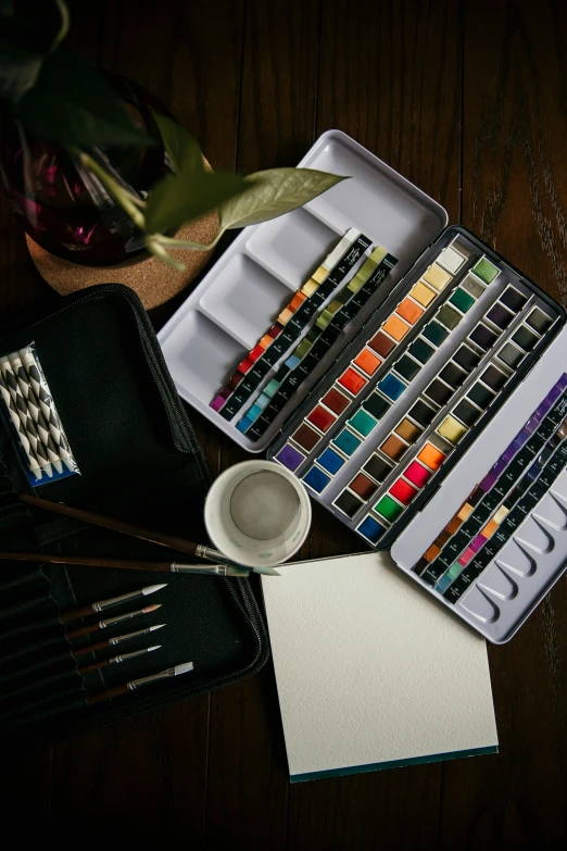 a wooden table with a box of watercolors