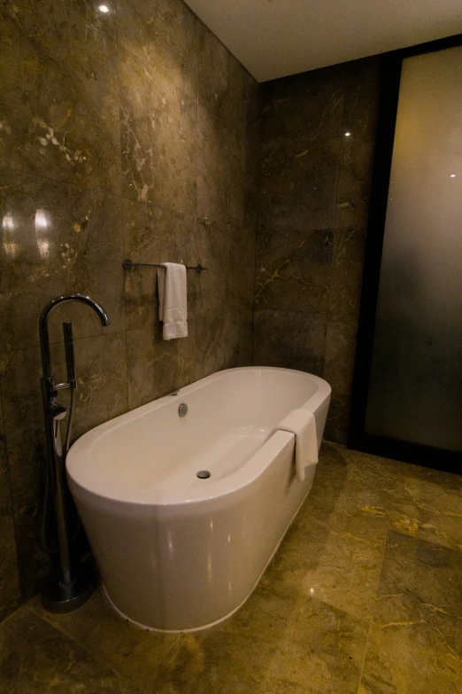 a bathtub in a bathroom with marble walls