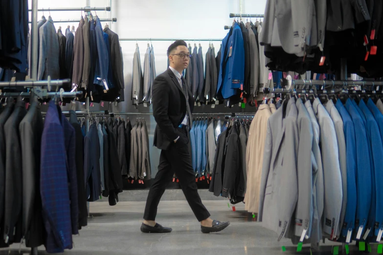 man walking in front of clothes and jackets