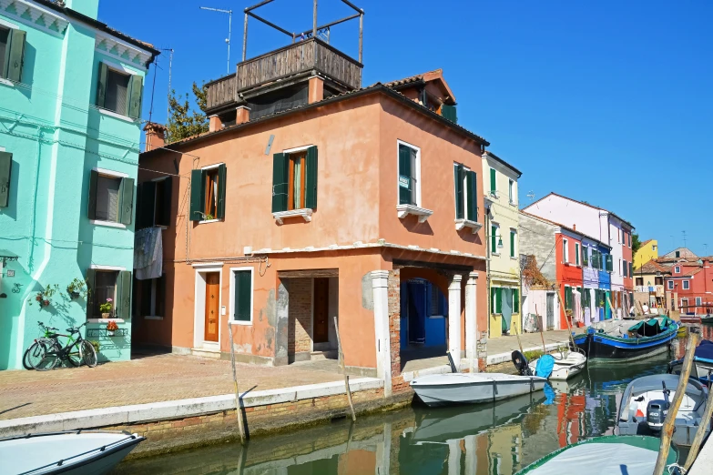 an orange house next to a dock with boats docked in the water