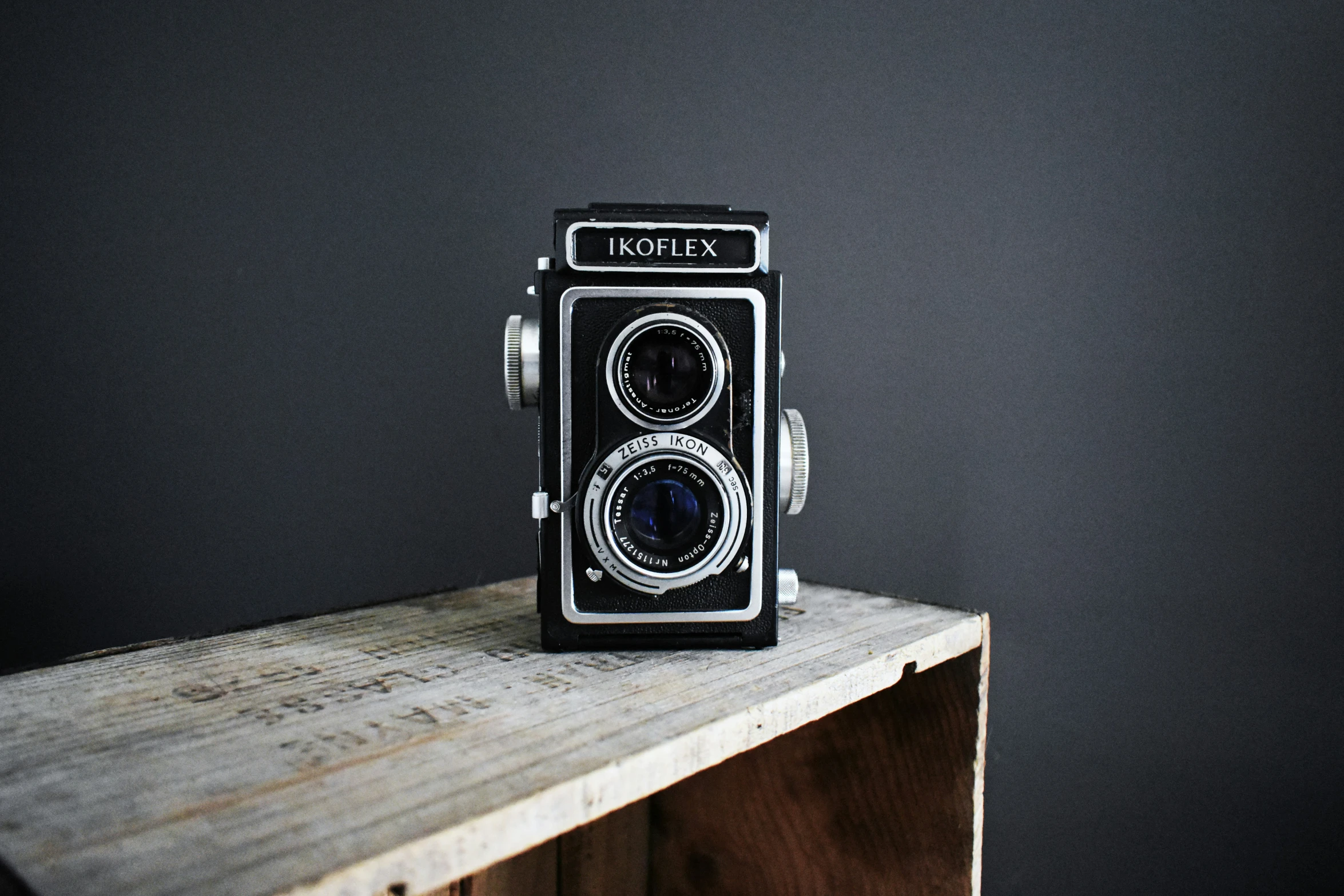 an old camera is sitting on a wood block