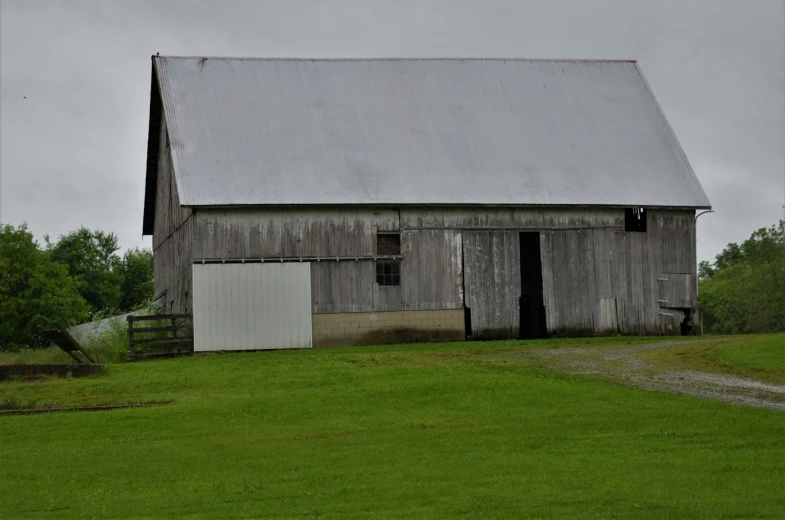 a large barn on the side of a dirt road