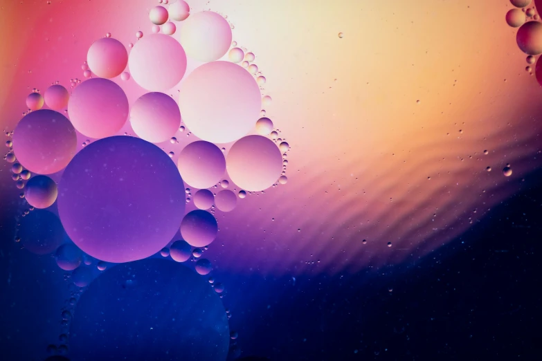 droplets in purple are floating on a water surface