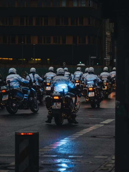 a large group of police officers riding motorcycles down the street
