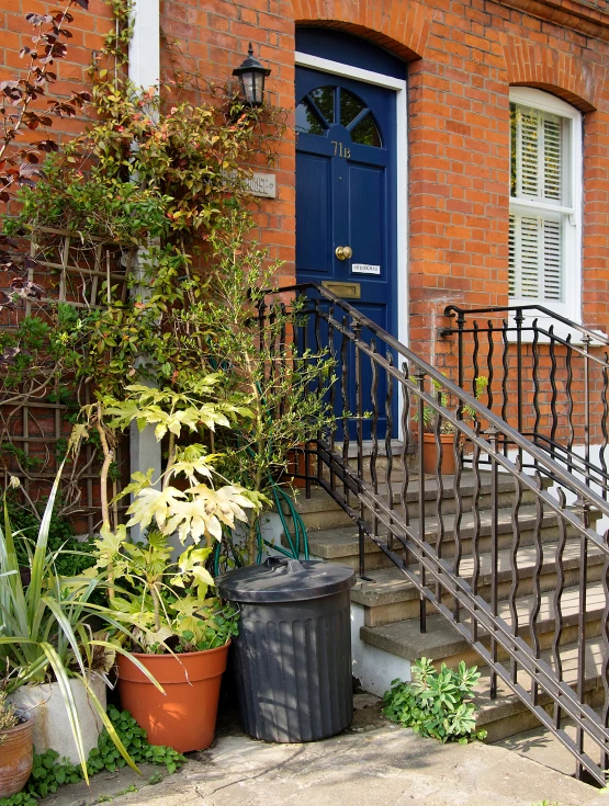 a brick house with stairs and blue door