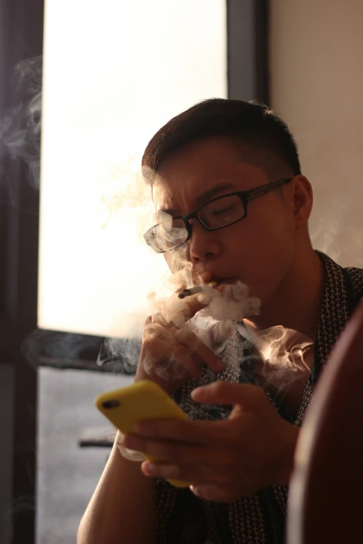 a man smokes and looks at his phone