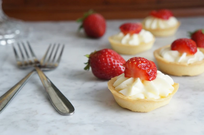 a plate of mini desserts with strawberries on top of them