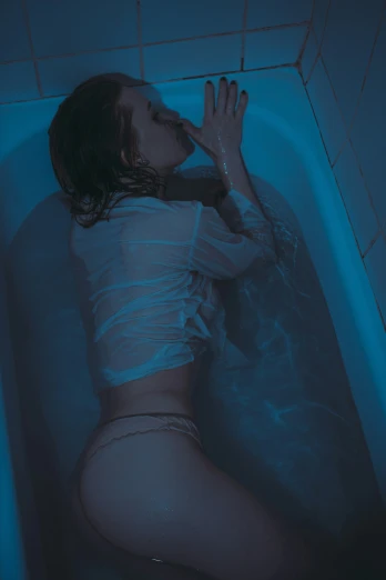 a person laying in a tub next to an object