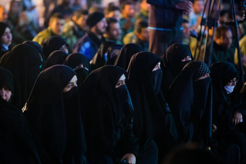 a group of people with hoods and wearing masks