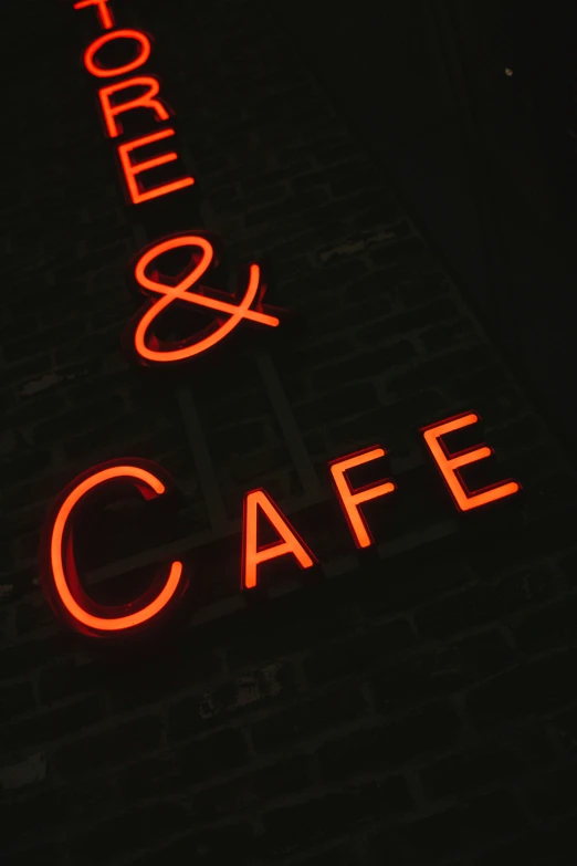 a lighted sign for a cafe and store in the dark