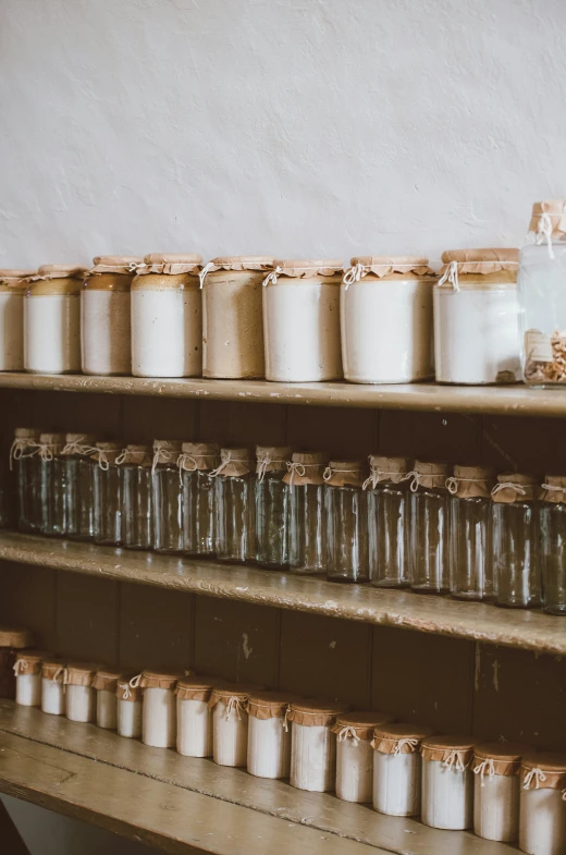 jars of various sizes and colors, in different sizes on wooden shelves