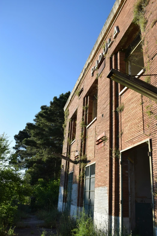 an old brick building has some overgrown grass