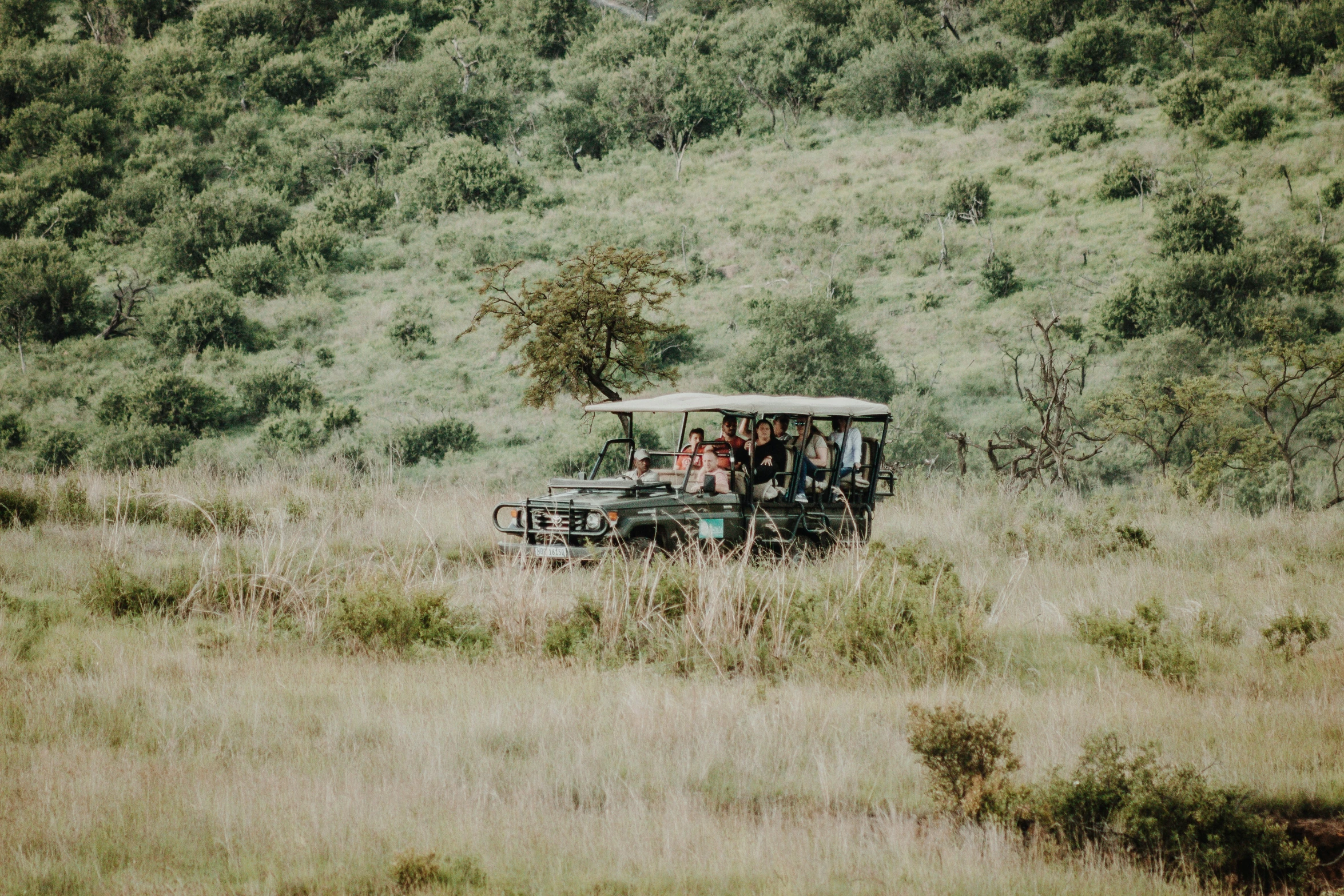 a group of people riding in an old fashioned trolley