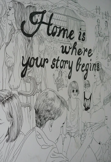 a close up of a drawing on a wall with the words, home is where your story begins