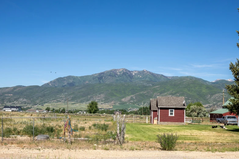 the house is next to a small shack in the grass